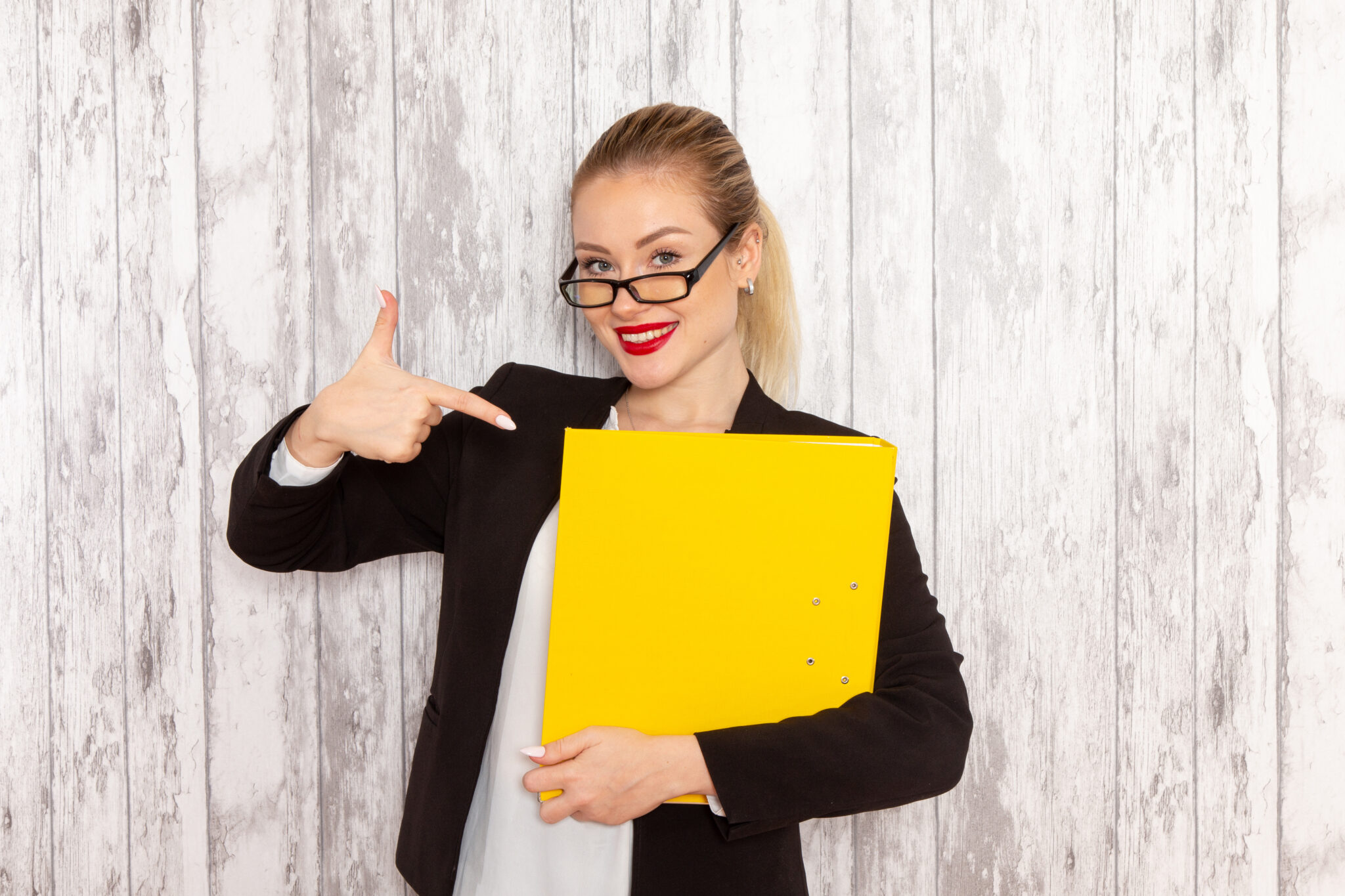 front-view-young-businesswoman-strict-clothes-black-jacket-holding-files-documents-smiling-white-surface